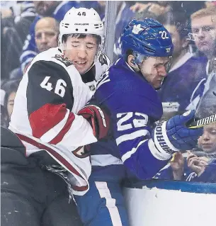  ?? STEVE RUSSELL TORONTO STAR ?? Ilya Lyubushkin of the Coyotes rides Leaf Nikita Zaitsev into the end boards in Sunday night’s game at Scotiabank Arena.