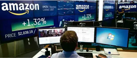  ?? Mark Lennihan/Associated Press ?? Operador da Nasdaq acompanha movimentaç­ão das ações da Amazon no pregão desta terça-feira (4), em Nova York