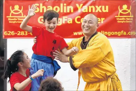  ?? Rick Loomis Los Angeles Times ?? MAX MORENO, 7, gets a hand up from Master Shi Yanxu. The master’s mission involves establishi­ng more learning centers like the one in Chinatown and raising funds for a temple he hopes to one day build. He teaches 300 students at three centers in Southern California.