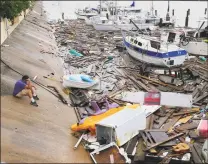  ?? Eric Gay / Associated Press ?? Allen Heath surveys the damage to a private marina after it was hit by Hurricane Hanna on Sunday in Corpus Christi, Texas. Heath's boat and about 30 others were lost or damaged.