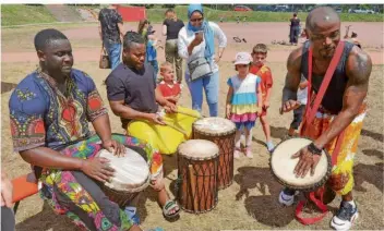  ?? FOTO: DAVID LEMM ?? Die Trommler Babacar Diop, Marco Akoube und Jean Baptiste Koffi (von links) begeistert­en die Kinder für die Kunst, diese Rhythmusin­strumente zu bedienen.