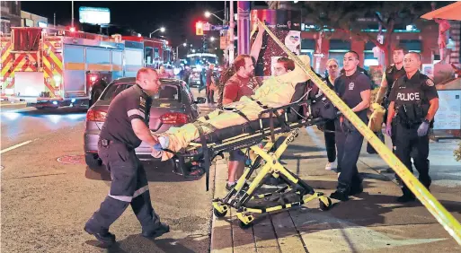  ?? RICHARD LAUTENS/TORONTO STAR ?? Emergency personnel transport an injured victim from the scene near Danforth and Logan Aves. on Sunday evening.