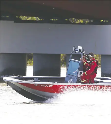  ?? JIM WELLS ?? Members of the Calgary Fire Department’s aquatics team monitor the Bow river on Tuesday amid high and fast water conditions.