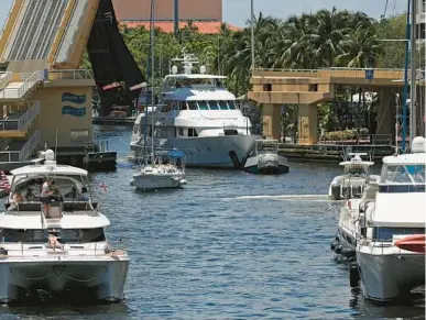  ?? JOHN MCCALL/SOUTH FLORIDA SUN SENTINEL ?? A mega yacht is towed through the New River on Saturday in Fort Lauderdale.