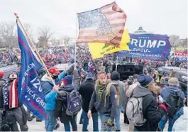  ?? MANUEL BALCE CENETA/AP ?? Insurrecti­onists loyal to then-President Donald Trump swarm the Capitol on Jan. 6 in Washington. Robert Palmer was sentenced to more than five years in prison.