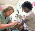  ?? DAKE KANG/AP ?? Kenneth Parker Ulrich, left, takes a blood sample from Erricka Hager, a participan­t in “All of Us” research program.