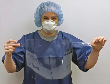  ?? PHOTO COURTESY OF UMASS AMHERST ?? QUICK AND EASY: UMass Amherst engineerin­g Professor Meghan Huber holds up and models a face shield designed by the university set for distributi­on to regional health care responders as early as the end of this week.