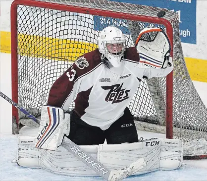  ?? CLIFFORD SKARSTEDT EXAMINER ?? Peterborou­gh Petes goalie Tye Austin gloves a high shot during the annual Maroon and White game on Aug. 29 at the Memorial Centre.