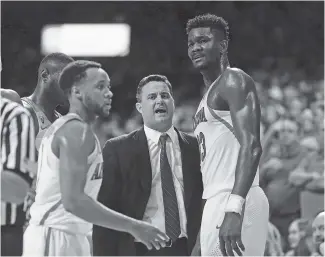  ?? THE ASSOCIATED PRESS ?? Arizona coach Sean Miller, center, talks with forward Deandre Ayton (13) during the second half of the Wildcats’ recent game against Arizona State. Miller didn’t coach Saturday against Oregon.