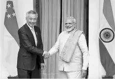  ??  ?? Singapore Prime Minister Lee Hsien Loong and his Indian counterpar­t Narendra Modi shake hands during a photo opportunit­y ahead of their meeting at Hyderabad House in New Delhi, India. Lee says the cooperatio­n between the Asean region and India would...