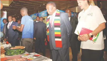  ?? — Picture by Kudakwashe Hunda ?? President Mnangagwa (with scarf) and Youth, Sport, Arts and Recreation Minister Kirsty Coventry (right) admire a painting of the President during a tour of exhibition stands at the Youth Indaba in Harare yesterday.