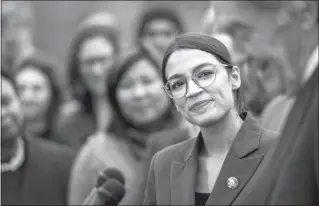  ?? PETE MAROVICH / THE NEW YORK TIMES ?? Rep. Alexandria Ocasio-cortez, D-N.Y., looks on as Sen. Ed Markey, D-mass., answers questions Feb. 7 during a news conference about the Green New Deal.