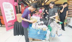  ?? — Gambar Bernama ?? LEBIH MURAH: Seorang pelanggan menuntut barangan yang dibelinya dengan menggunaka­n penyedia perkhidmat­an jualan barangan runcit dalam talian tempatan, Potboy Grocery di Kuala Lumpur baru-baru ini. Chew berkata seramai 18,000 pengunjung dalam dan luar...