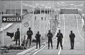  ?? FERNANDO LLANO/AP ?? Venezuelan Bolivarian Army soldiers guard the Tienditas Internatio­nal Bridge that links Colombia and Venezuela.