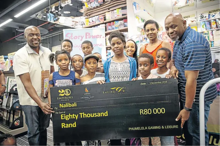  ?? / DANIEL BORN ?? Sowetan editor Sthembiso Msomi, far right, presenting a cheque to Bongile Mtolo, far left, for the Nal’ibali Trust at Exclusive Books in Killarney, Johannesbu­rg. Nal'ibali read and donated books to children from the Thuma Mina Book Club.