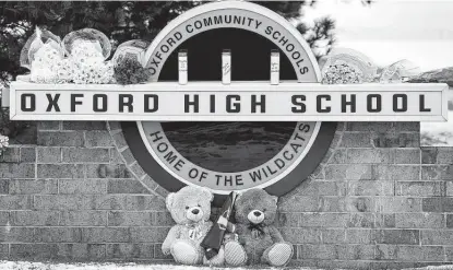  ?? Photos by Scott Olson / Getty Images ?? Stuffed bears and flowers sit at a memorial outside the high school in Oxford, Mich., where police say a 15-year-old opened fire with a newly purchased handgun, killing four students and wounding seven others.