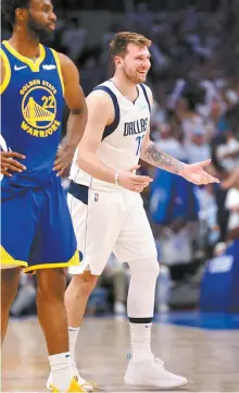  ?? AP-Yonhap ?? Dallas Mavericks’ Luka Doncic, right, reacts to a basket, next to Golden State Warriors’ Andrew Wiggins during the third quarter in Game 4 of NBA basketball playoffs Western Conference finals in Dallas, Tuesday.