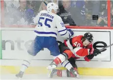  ?? ADRIAN WYLD/THE CANADIAN PRESS ?? Toronto Maple Leafs defenceman Andreas Borgman checks Ottawa Senators centre Gabriel Dumont into the boards in the first period of Saturday’s 4-3 Leafs win in Ottawa.