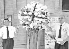  ??  ?? Chong and fellow Tzu Chi volunteer Ong Tuen Yiok, with the art installati­on that depicts rubbish suffocatin­g Sabah and the world at Yayasan Sabah.