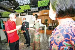 ?? THE STRAITS TIMES ?? Singapore Prime Minister Lee Hsien Loong gives red packets to SIA cabin crew and pilots, as well as support staff on shift at the SIA Cabin Crew Control Centre on Friday.