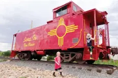  ?? RaCHEL WALKER/THE WASHINGTON POST ?? The author’s sons explore an old railcar secured on the tracks during a visit to the Santa Fe Railyard.