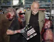  ??  ?? Director George Romero poses with some fans dressed as zombies after accepting a special award during the Toronto Internatio­nal Film Festival in Toronto. Romero, whose classic “Night of the Living Dead” and other horror films turned zombie movies into...