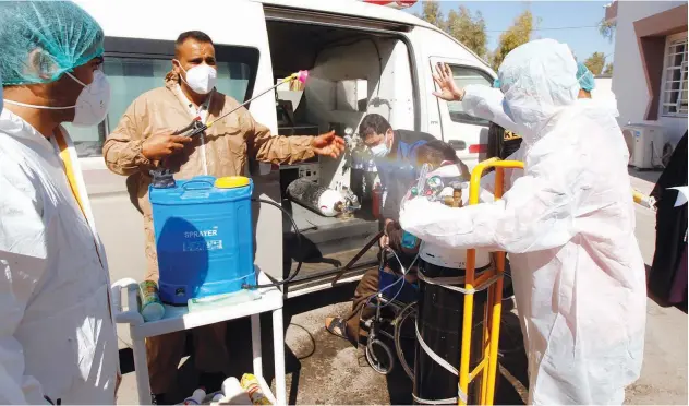  ?? Reuters ?? ↑
A medical team member sprays disinfecta­nt on a person at a hospital in Najaf, Iraq, on Friday.