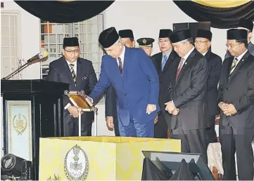  ??  ?? Sultan Nazrin signing a plaque at the ceremony to declare Bagan Datuk as the 12th administra­tive district in Perak. Also seen are Ahmad Zahid and Perak Menteri Besar Datuk Seri Dr Zambry Abdul Kadir (right). — Bernama photo