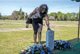  ?? ?? Hanjari Neavins, the daughter of U.S. Army Pvt. Albert King’s first cousin and King’s main advocate, lingers at his grave following Sunday’s funeral.