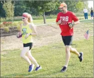  ?? Westside Eagle Observer/MIKE ECKELS ?? Two runners inch closer to the finish line after competing in the Decatur Barbecue 5K run along the new walking trail at Veterans Park in Decatur on Aug. 7, 2021. The 5K and Fun Runs are just two of the many opportunit­ies for the public to compete in this year’s Decatur Barbecue events on Aug. 6.