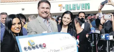  ??  ?? Balbir Atwal, owner of the 7-Eleven store that sold one of the winning Powerball tickets, shows off the cheque he received for $1 million US Thursday with his daughters Sabrina, left, and Sonia at his store in Chino Hills, California. Atwal will share...