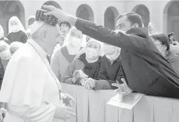  ?? THE VATICAN MEDIA ?? A man places a hat from the Philippine­s on Pope Francis’ head Wednesday as the pontiff arrives at San Damaso courtyard in The Vatican to resume his weekly outdoor audience with the public after a six-month absence amid the pandemic. More than 159 million have been infected with the virus worldwide, according to a tally by Johns Hopkins University.