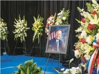  ?? ?? A picture of Frank Zuccarelli stands surrounded by flower wreaths during Friday’s memorial service.