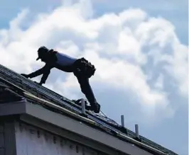  ?? DAVID J. PHILLIP/AP ?? A roofer works on a home under constructi­on. Florida’s insurance commission­er is telling insurance companies that they can reduce full-roof replacemen­t benefits as long as consumers choose it in exchange for a premium discount.