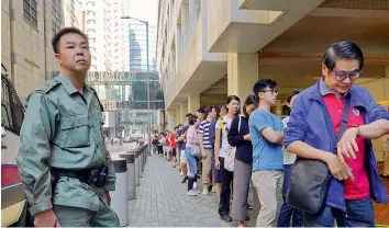  ?? — AFP ?? People queue to cast their vote during the district council elections in North Point in Hong Kong on Sunday.