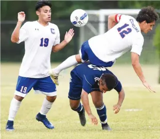  ?? STAFF PHOTOS BY ROBIN RUDD ?? Cleveland’s River Shaffer (12) is upended by a Cookeville player as teammate Julio Gallegos (19) looks on during their Region 3-AAA championsh­ip match Thursday night in Cleveland. The Blue Raiders won 2-0.