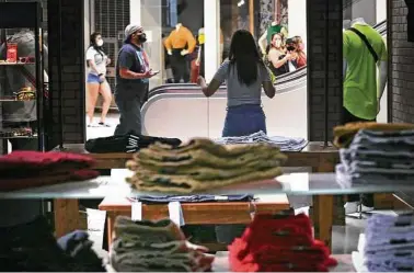  ?? Bob Owen / Staff photograph­er ?? Dina Manriguez of Freestyle Clothing Mall greets customers as Ingram Park Mall reopens May 1. About 94 percent of the area’s retail space was occupied at midyear, according to a July report.