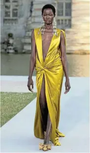  ?? Picture: MARC PIASECKI ?? MAKING A STATEMENT: A model wears statement earrings paired with silky honeycomb yellow evening gown