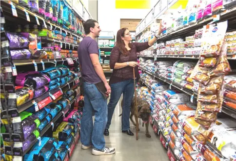  ??  ?? An employee assists a customer with dog food at a Petco store in Clark, New Jersey on Oct 2, 2015. — WP-Bloomberg photo
