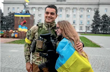  ?? AP ?? A girl and a Ukrainian officer hug as they celebrate the recapturin­g in Kherson, Ukraine.