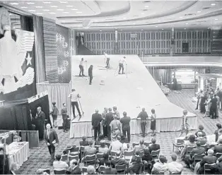  ?? PHOTO: ROBERT WALKER\NYT ?? LEFT
Skiers climb a 15m ‘mini-mountain’ erected in the Grand Ballroom of the Statler-Hilton, now the Hotel Pennsylvan­ia, on Nov 21, 1963.
BELOW LEFT Andrea Cooke waits with her dogs, two Irish Setters and one English Setter, during a dog show at the Hotel Pennsylvan­ia in 1970.