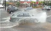  ??  ?? A car drives through a flooded intersecti­on in Studio City, Calif., in February 2014. Rain is a chief cause of car accidents.
ROBYN BECK,
AFP/GETTY IMAGES