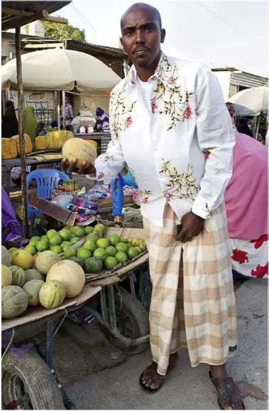  ??  ?? MARKet DAY: Hassan Farah shopping on the stalls at Hargeisa. Top: Goats are herded though Iranka Deriyanka, the family’s home. Right: Mo’s sister Nimo with one of her four children