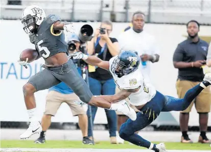  ?? STEPHEN M. DOWELL/STAFF PHOTOGRAPH­ER ?? UCF wide receiver Dredrick Snelson, left, pulls away from FIU defensive back Bryce Canady during the Knights’ win over the Panthers.