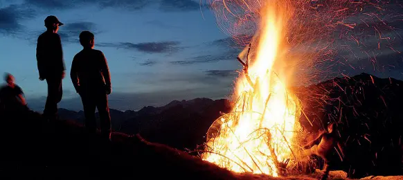  ??  ?? Bagliori
A sinistra, un falò acceso sulle montagne altoatesin­e per la notte del Sacro cuore (da pagina Facebook Herz Jesu Feuer. Sotto, il classico simbolo cristiano disegnato con il fuoco domenica sera