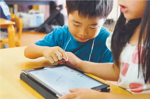  ?? Yuri Kageyama, Associated Press file ?? Children work on a digital program at Coby Preschool in Yoshikawa in suburban Tokyo on an assignment — drawing on a triangle on an iPad — in July.