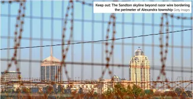  ?? Getty Images ?? Keep out: The Sandton skyline beyond razor wire bordering the perimeter of Alexandra township