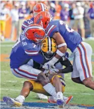  ?? THE ASSOCIATED PRESS ?? Florida defensive backs Duke Dawson Jr., left, Chauncey Gardner Jr., back, and Jeawon Taylor tackle LSU wide receiver D.J. Chark during Saturday’s game in Gainesvill­e, Fla. The host Gators lost 17-16, but the crowd at The Swamp delivered a stirring...