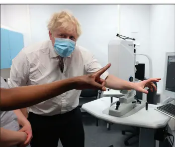  ?? Ian Vogler The Associated Press ?? Britain’s Prime Minister Boris Johnson visits a hospital in North London on Tuesday.