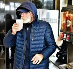  ?? MARION CALLAHAN/THE INTELLIGEN­CER VIA AP ?? Richard Valier, 70, takes a sip of water at the Burger King in Upper Moreland, Pa., in March. Valier said he is grateful for the compassion of the manager of the restaurant, who lets him get water and rest in a booth in the mornings throughout the week. Valier has been living homeless on the streets, sleeping in a tent or shelter, for more than five years.